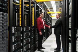 two men shaking hands in a server room